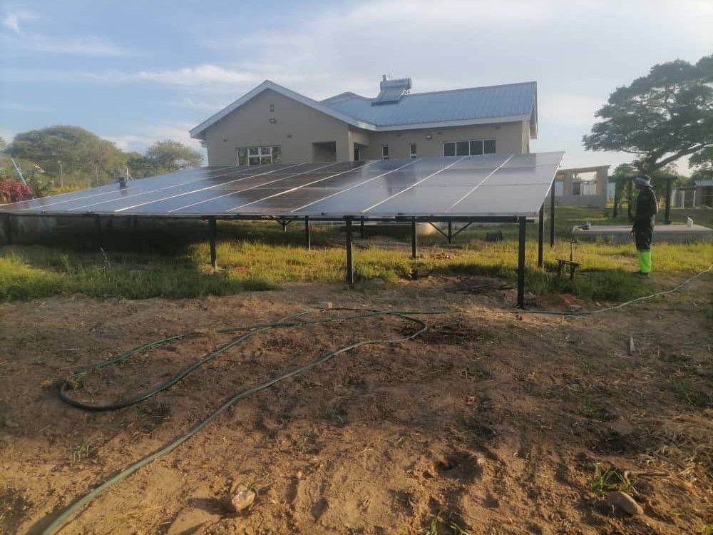 Ground-mounted solar panel array installed beside a home
